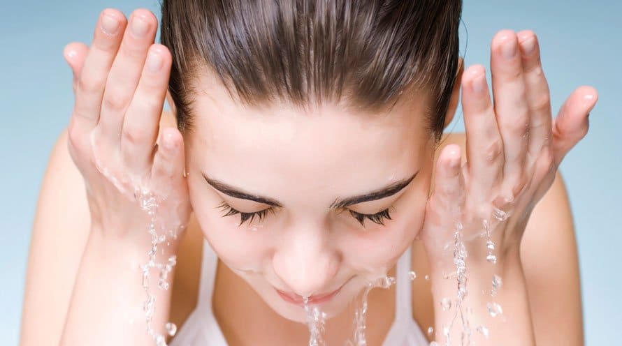 Het gezicht wordt gereinigd met water