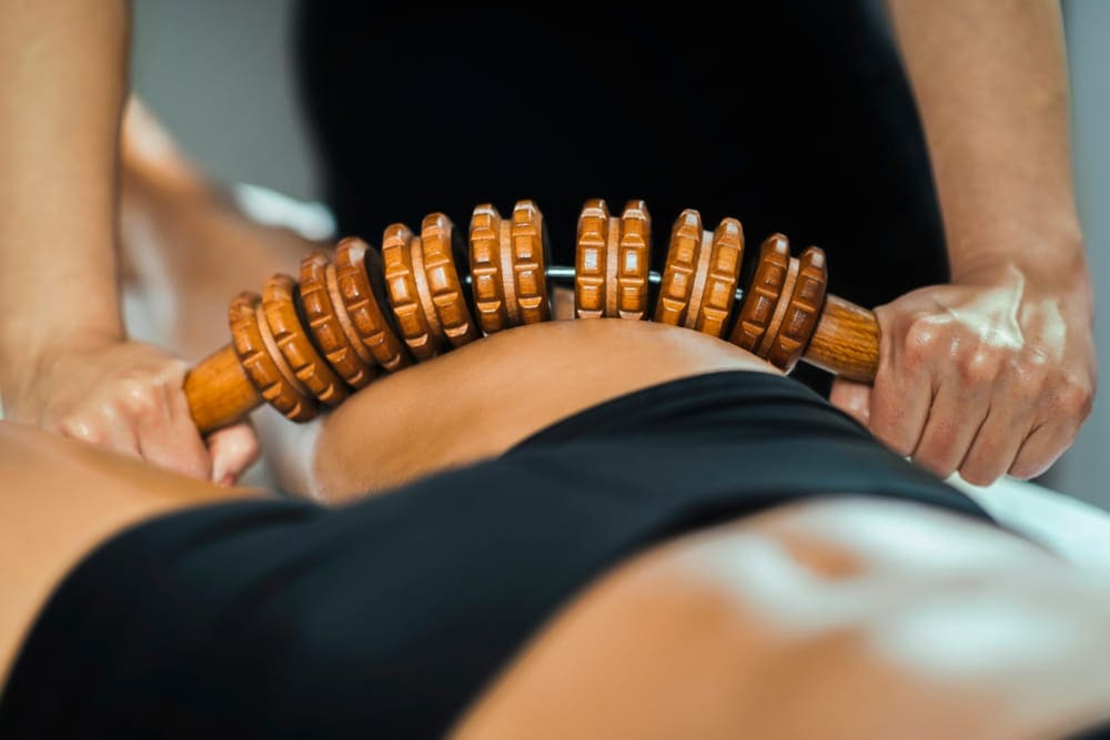 Lichaamsbehandeling met een houten massageroller